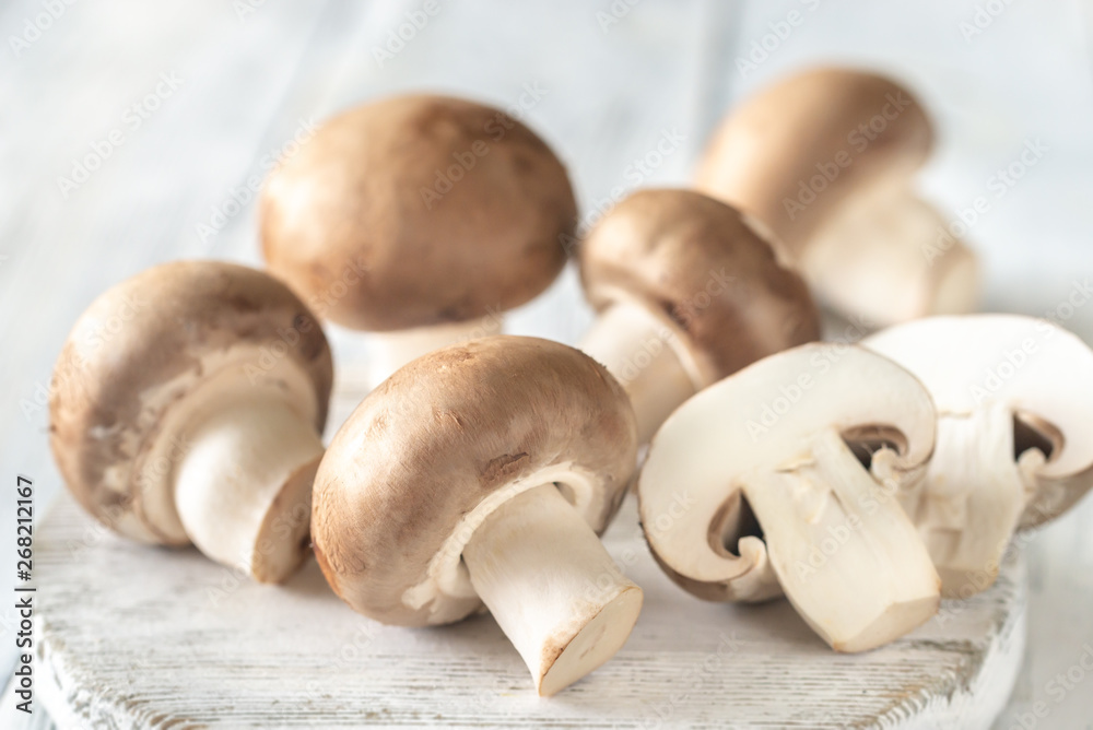 Champignon mushrooms on the wooden board Champignon mushrooms on the wooden board