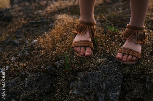 Girl's feet and sandals outside in nature photo