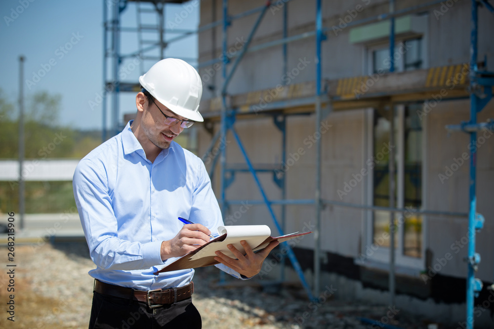 Architect inspects construction outside talking on the phone. Architect inspects construction outside talking on the phone.