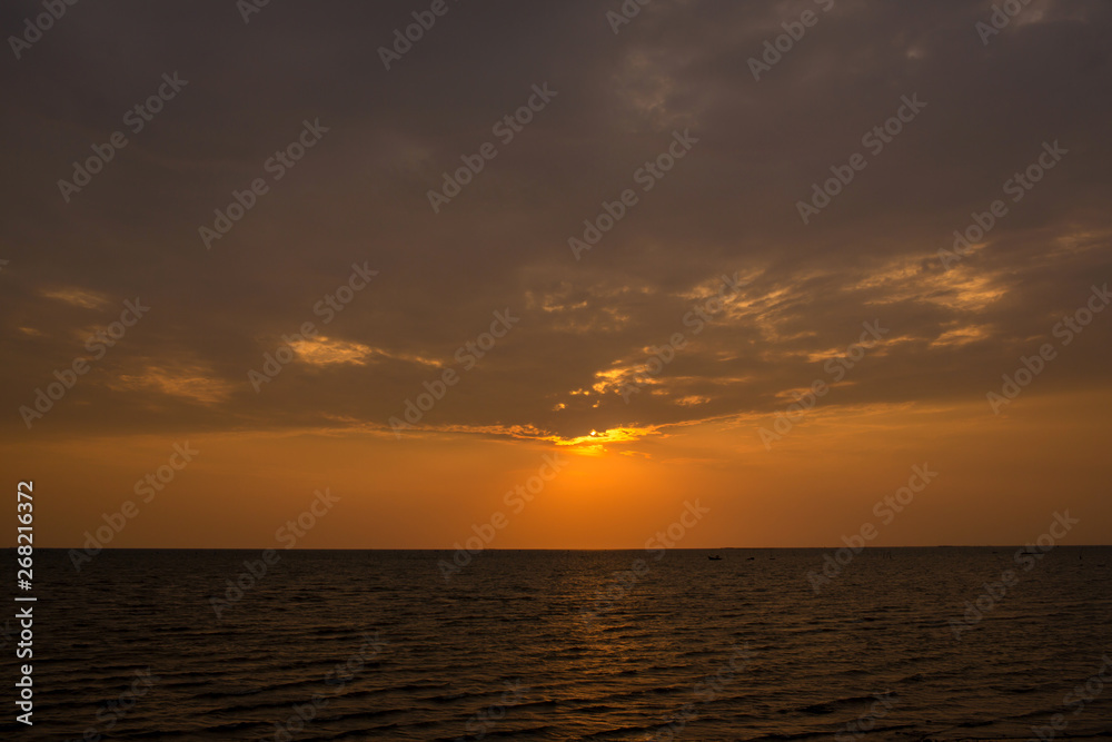 Bright sunset with large yellow sun under the sea surface. sunrise in the sea. Beautiful sunset above the sea.