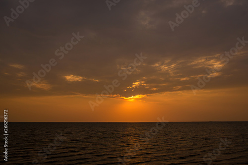 Bright sunset with large yellow sun under the sea surface. sunrise in the sea. Beautiful sunset above the sea. © kanpisut