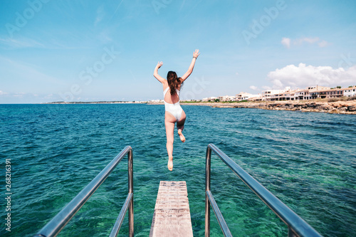 Woman jumping off a springboard photo
