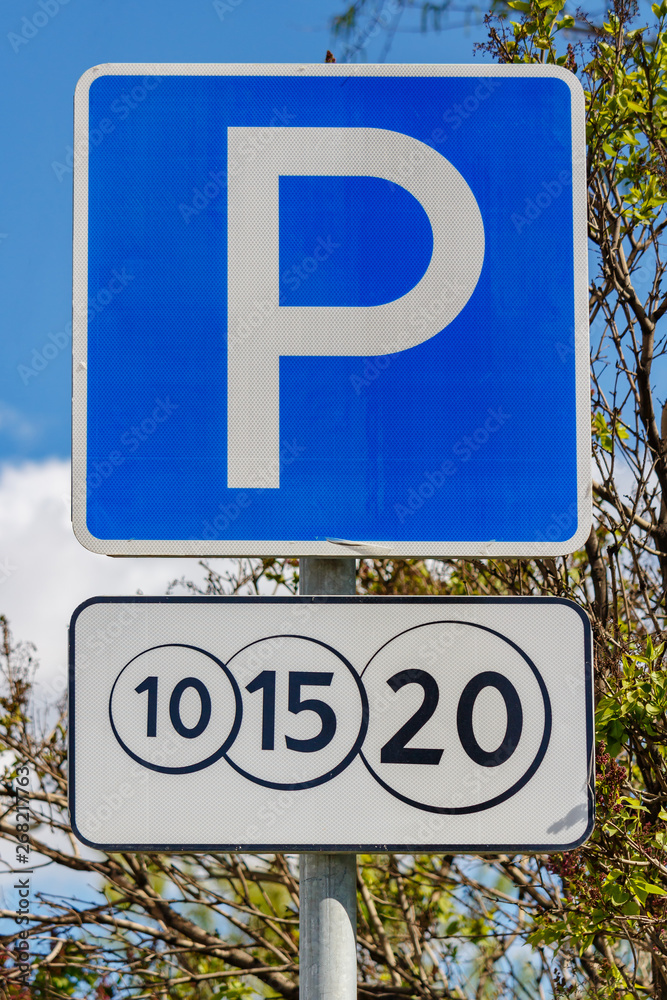 Road sign Paid parking against green trees and blue sky in sunny day closeup Road sign Paid parking against green trees and blue sky in sunny day closeup