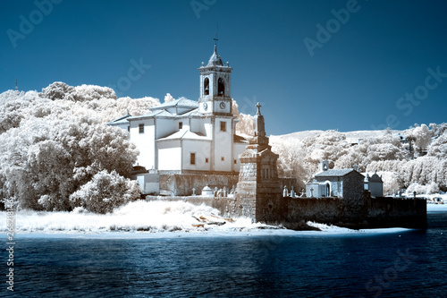 Church and cemetery by the sea in infrared ligh photo