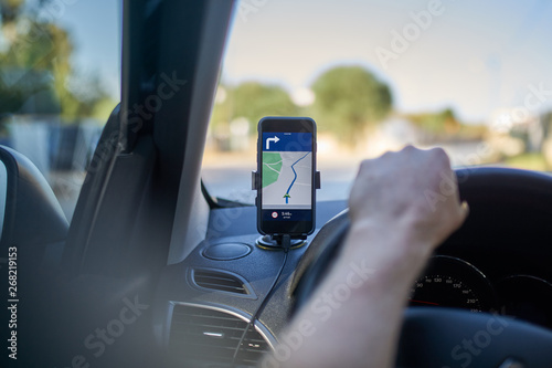 Driver using a GPS navigator on a cell phone photo