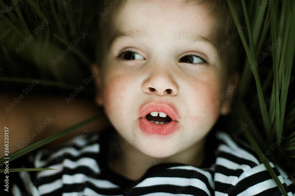 Close up of boy lying on green grass