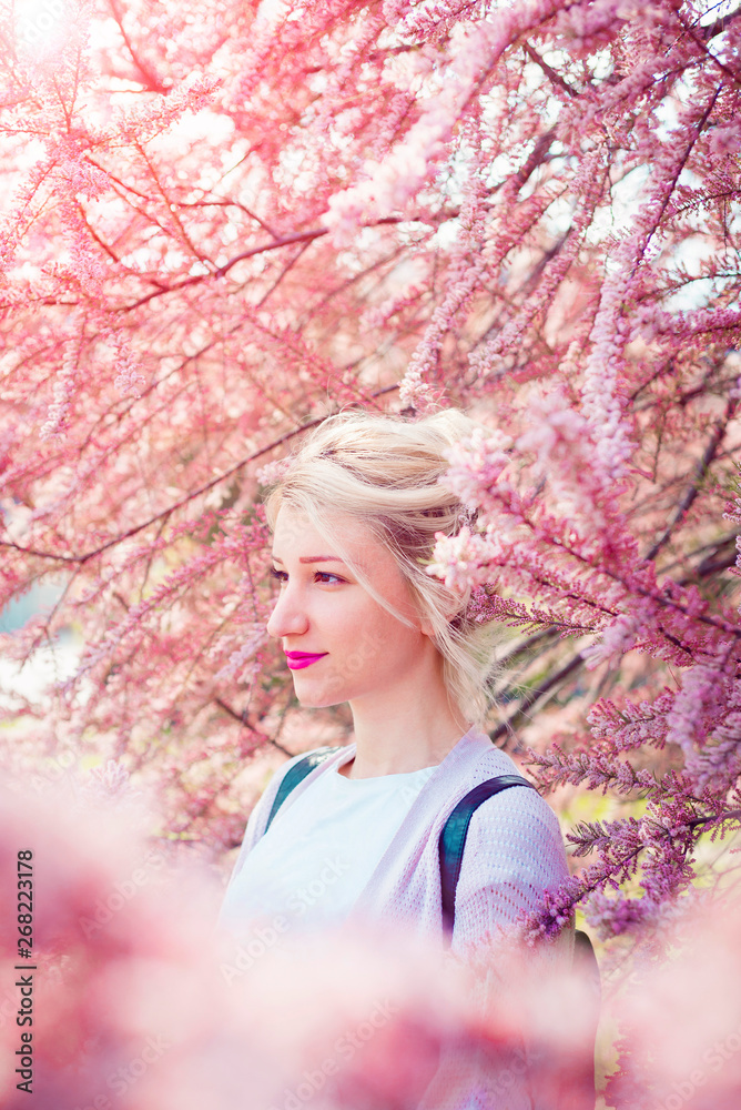 Young woman portrait in blooming pink tree Young woman portrait in blooming pink tree