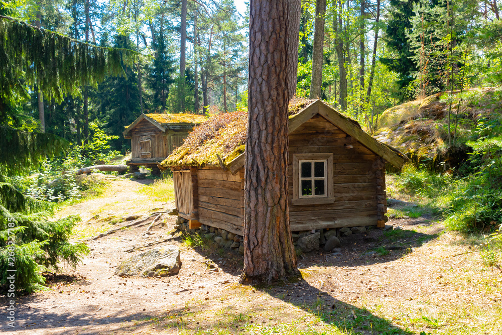 An old authentic 18th century wooden farmhouse in the middle of a forest on Seurasaari island in Helsinki in Finland on a summer day. Beautiful Finland. An old authentic 18th century wooden farmhouse in the middle of a forest on Seurasaari island in Helsinki in Finland on a summer day. Beautiful Finland.