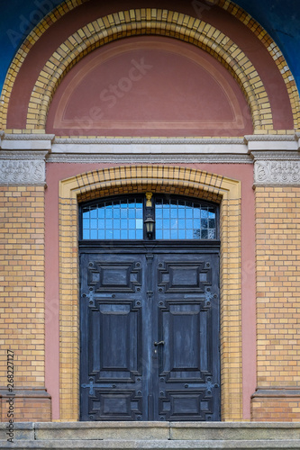 old heavy wooden door at a brick house © Matthias