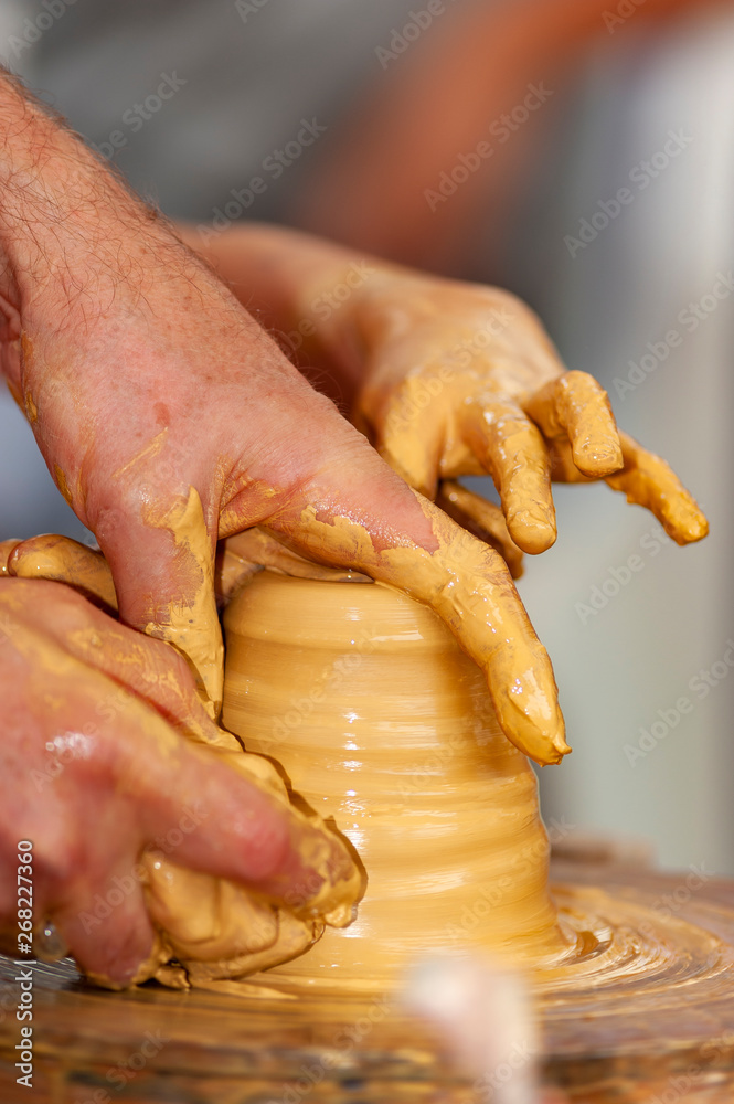 skilled hands, dirty with earth, model, mold and paint the clay, creating works of art
