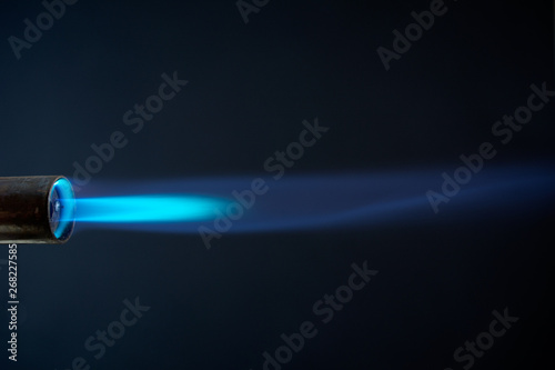 blowtorch blue flame close up dark background