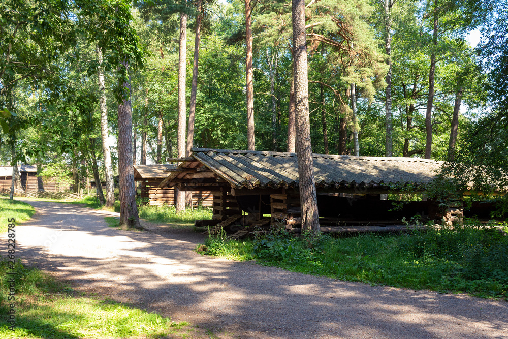 Old authentic traditional wooden long barn in the woods to store a long antique fishing boat on the island of Seurasaari in Helsinki in Finland on a summer sunny day.