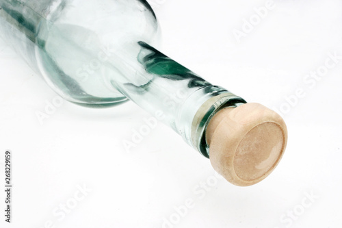 Glass bottle with a cork at the white background