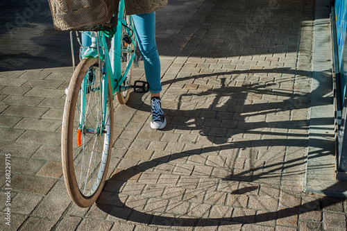 walking around the city with a bicycle. a Dutch bicycle with a shadow falling beautifully from it onto the pavement