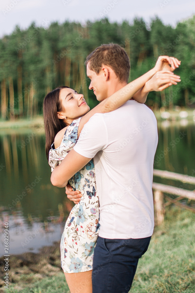 Young loving couple hugging near lake. Young loving couple hugging near lake.