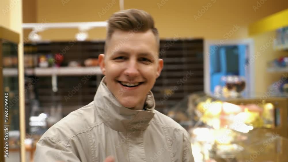 Joyful young customer have fun in the sweets shop Joyful young customer have fun in the sweets shop