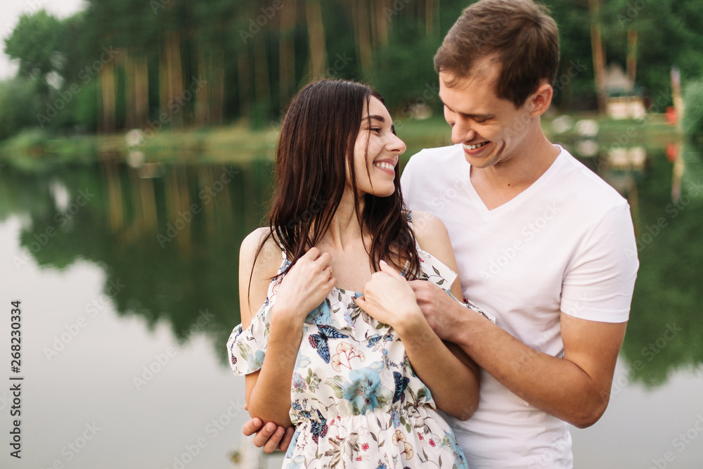 Young loving couple hugging near lake on sunset. Young loving couple hugging near lake on sunset.