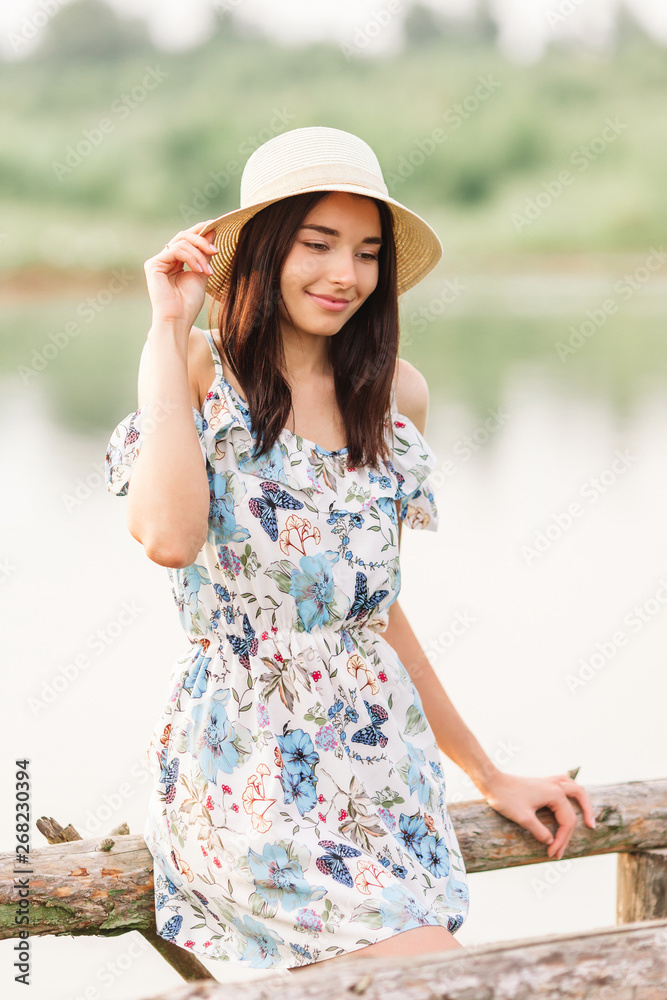 Young beautiful woman posing near lake.