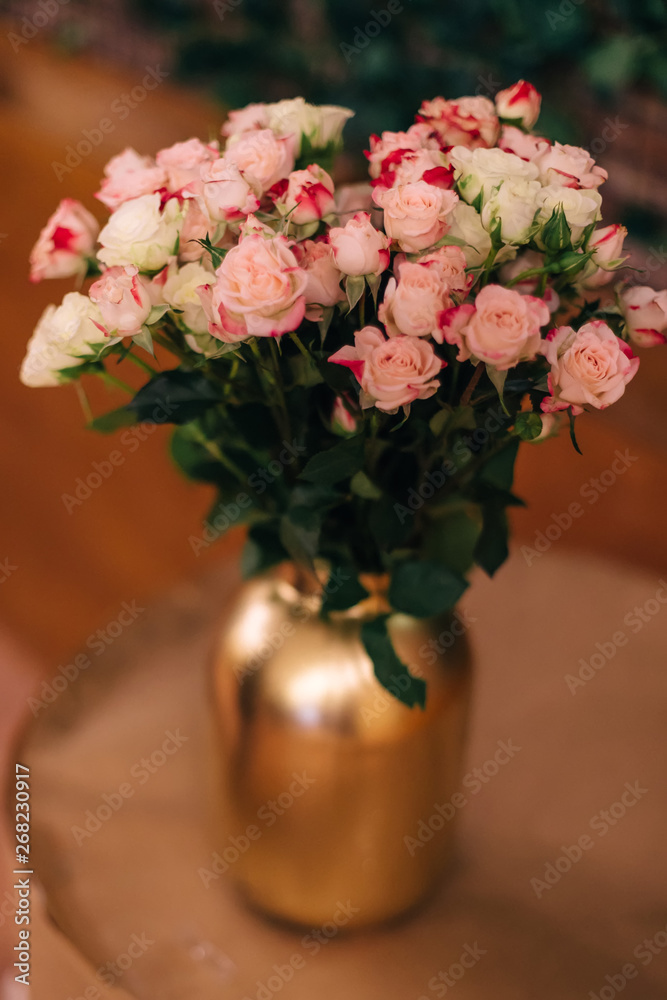 Fototapeta premium Close-up of a golden vase with beautiful roses
