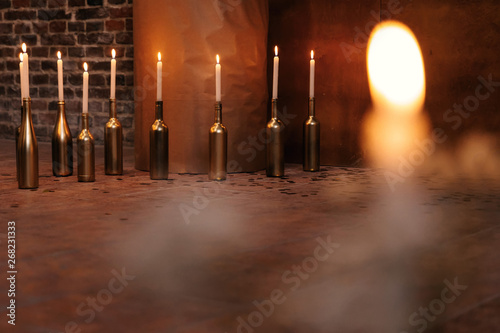 bottles with candles on the background of the wall. wedding rece