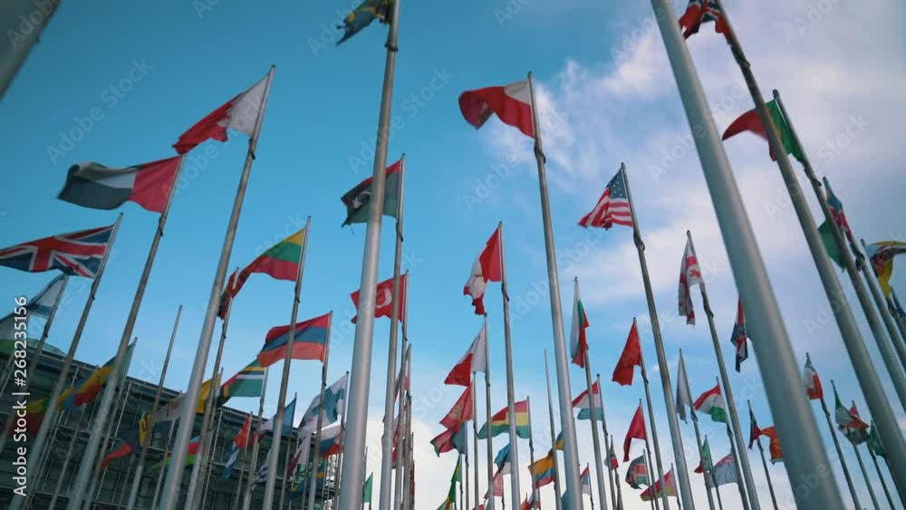 International flags of different countries waving in the wind on flagpoles - Ukrainian, Norway, Poland, Canadian, Georgian, Armenian, Lithuanian, Austrian and more