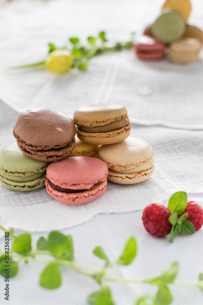 Obraz premium Macarons on white background and rustic wooden table