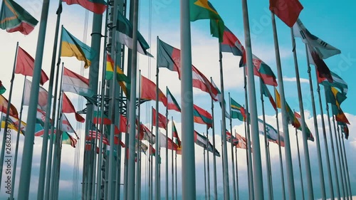 International flags of different countries waving in the wind on flagpoles - Ukrainian, Norway, Poland, Canadian, Georgian, Armenian, Lithuanian, Austrian and more