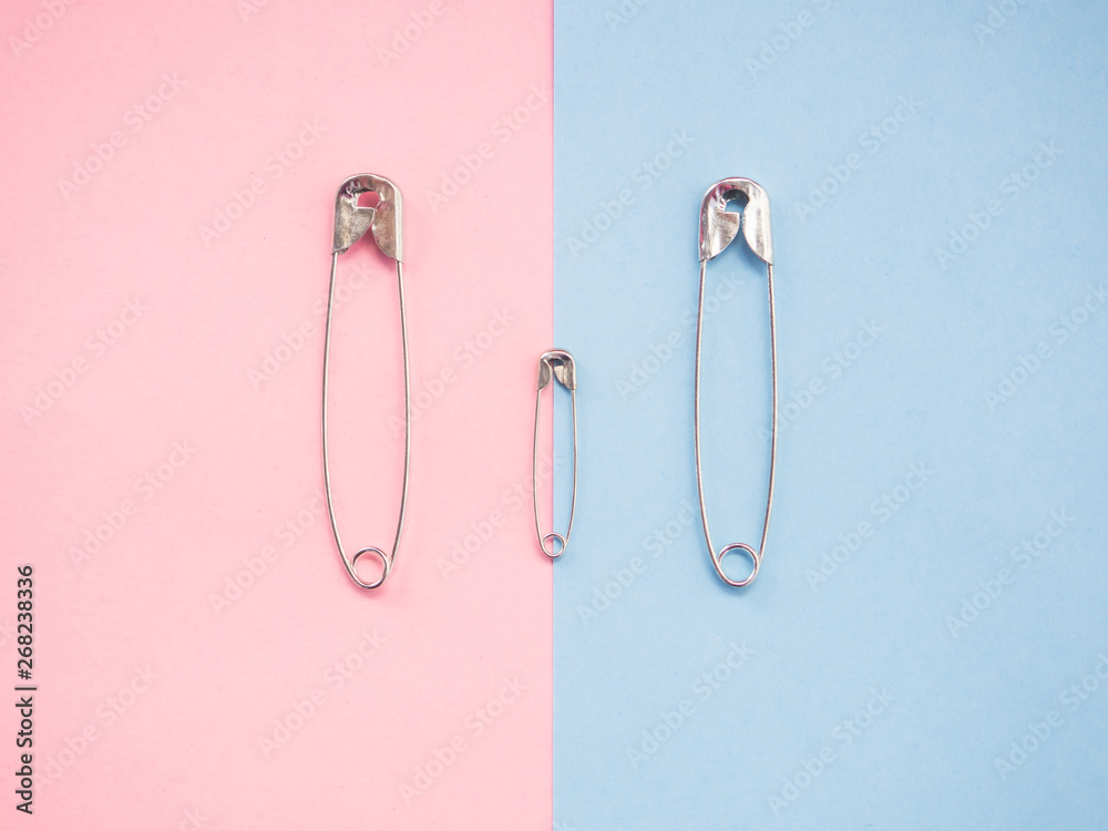 Several safety pins of various sizes in human representation. Concept of traditional family with children