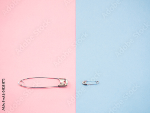 Two safety pins representing a man and a woman. Concept of machismo and feminism