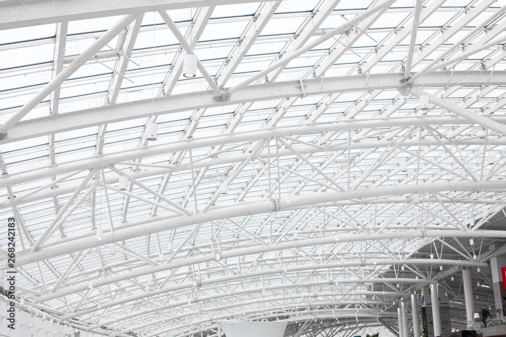 Atrium. Daylight shines through a glass metal framework. Shopping center structure roof. Mall Lighting. Atrium. Daylight shines through a glass metal framework. Shopping center structure roof. Mall Lighting.