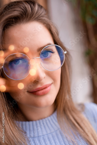 Brown-eyed girl in glasses with a garland in May 2019 Moscow