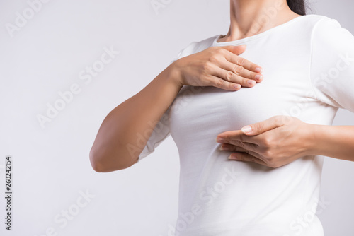 Wallpaper Mural Woman hand checking lumps on her breast for signs of breast cancer on gray background. Healthcare concept. Torontodigital.ca