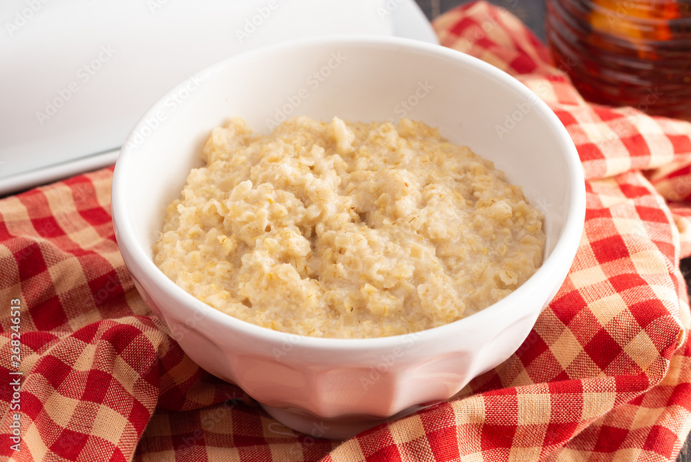 Plain Oatmeal on a Wooden Table with Checkered Table Cloth Plain Oatmeal on a Wooden Table with Checkered Table Cloth