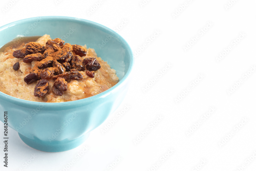 Cinnamon Raisin Oatmeal in a Blue Bowl on a White Background Cinnamon Raisin Oatmeal in a Blue Bowl on a White Background