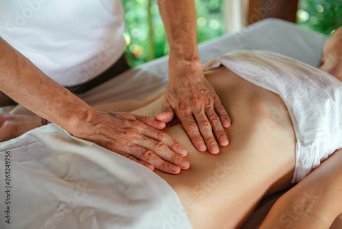 Massage the abdomen. Master's hands. photo
