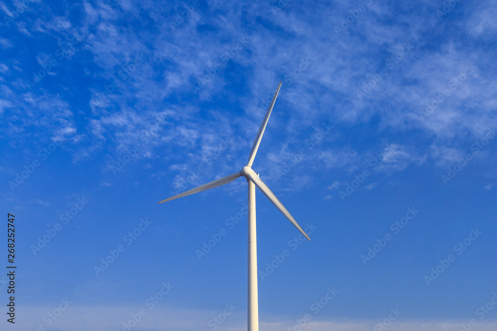 A windmill that generates electricity on the prairie