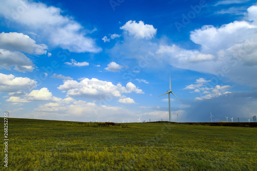 A windmill that generates electricity on the prairie