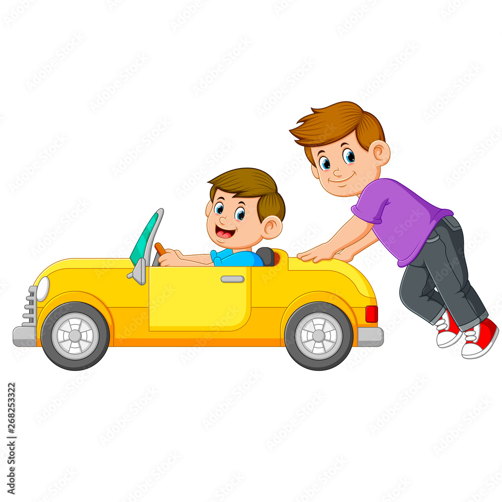 the boy is pushing the yellow car with his friend  on it