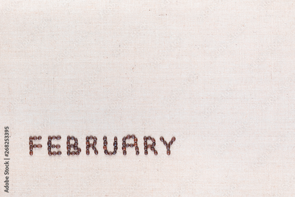The word February written with coffee beans shot from above, aligned at the bottom left.