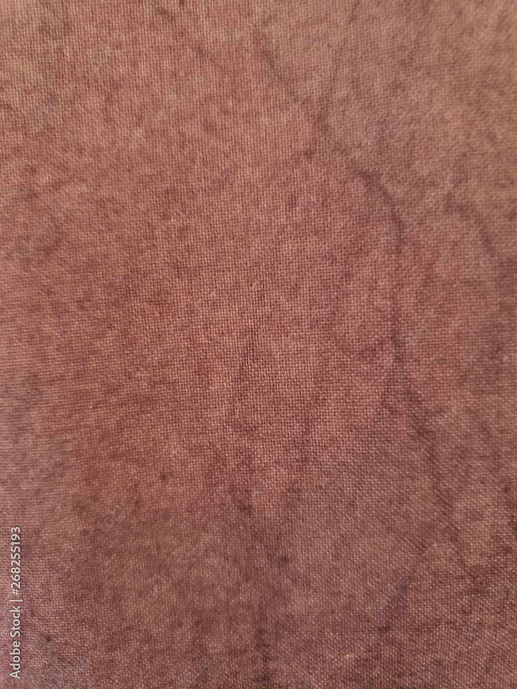 Light brown fabric with streaks of darker color creating a design Light brown fabric with streaks of darker color creating a design