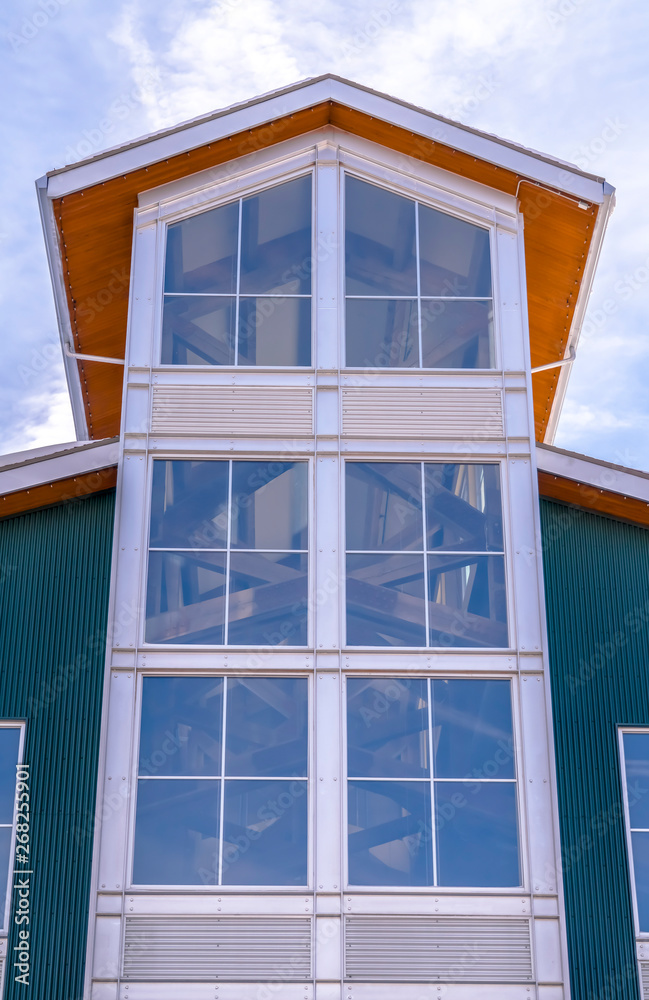 Large glass window of a building with a bright and cloudy blue sky background