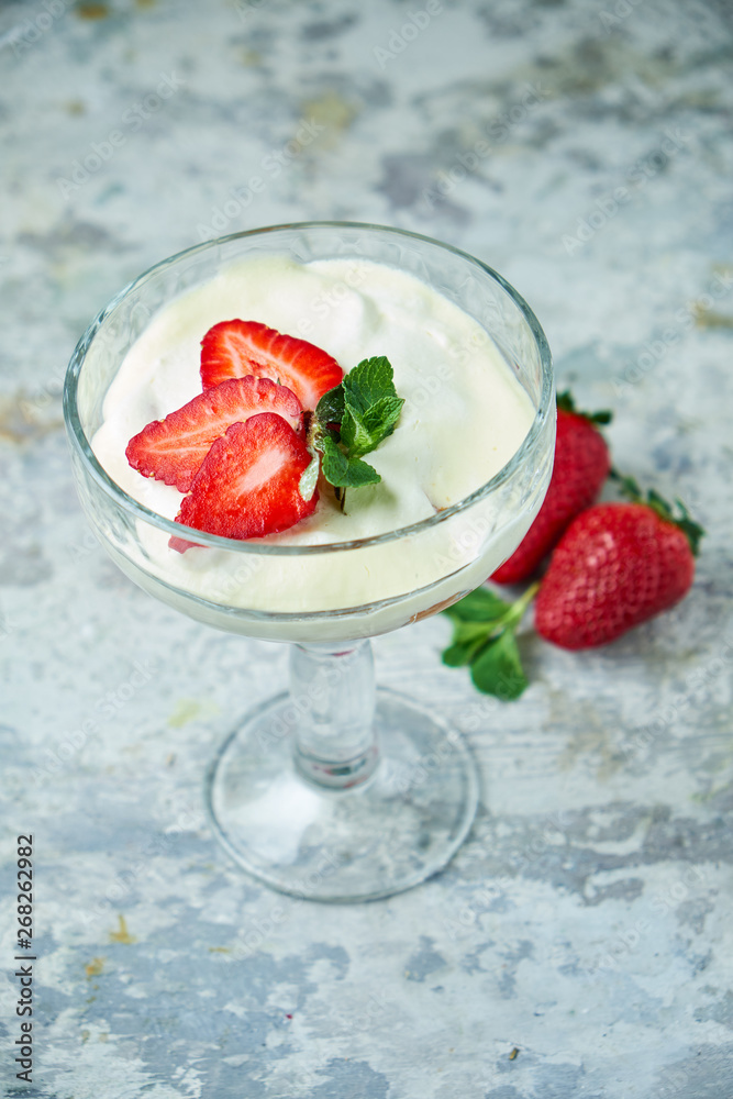 Ice cream with strawberries in a glass vase. Gray textured background. Dessert Ice cream with strawberries in a glass vase. Gray textured background. Dessert