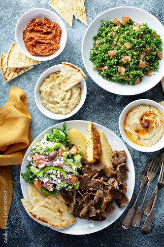 Fototapeta Naklejka Na Ścianę i Meble -  Mediterranean food on the table, gyro platter, pita and dips and tabbouleh