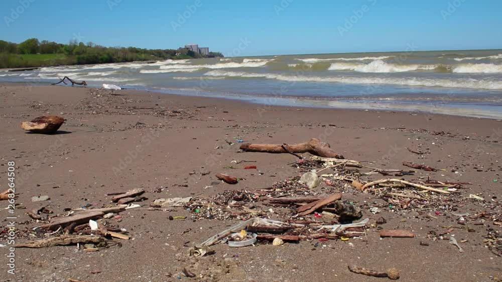 Trash on the beach in Cleveland, Ohio. Great Lake Erie polluted with single use plastic and other garbage. Trash on the beach in Cleveland, Ohio. Great Lake Erie polluted with single use plastic and other garbage.