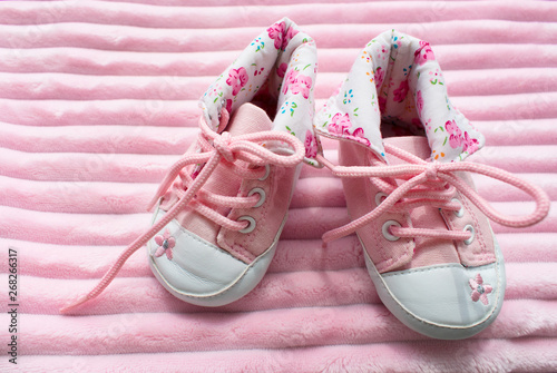 A pair of children's sneakers for girls on a pink background