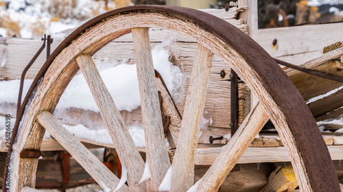 Panorama Close up of the wheel of an old wooden cart against a snowy landscape in winter