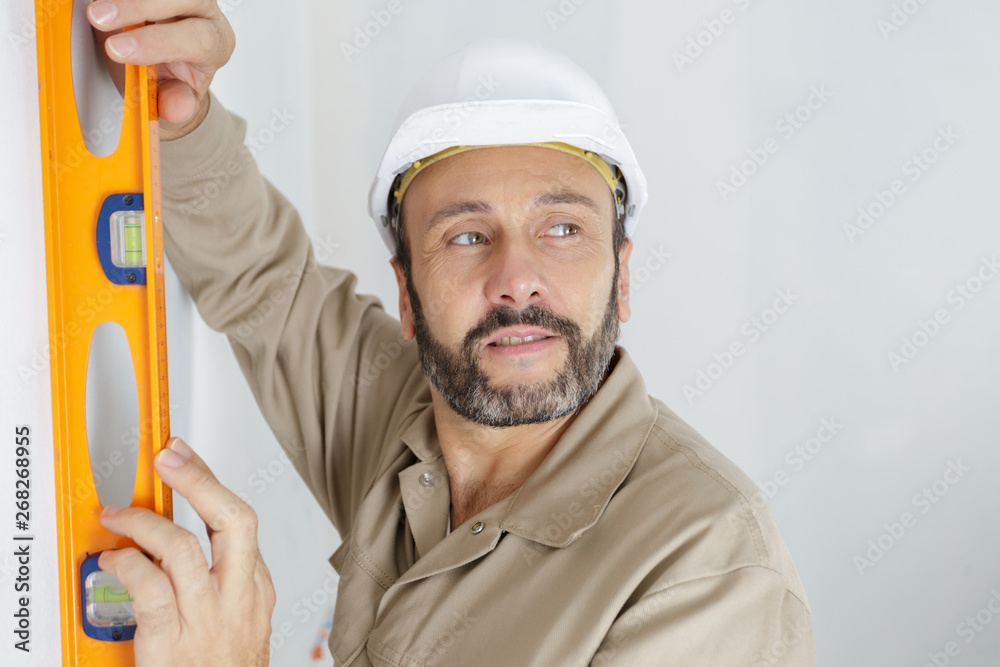 tradesman using spirit level on wall tradesman using spirit level on wall