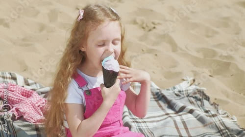 Girl eats ice cream outdoors.