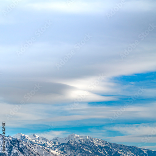 Clear Square Striking mountain with rugged slopes under vast blue sky with clouds © Jason