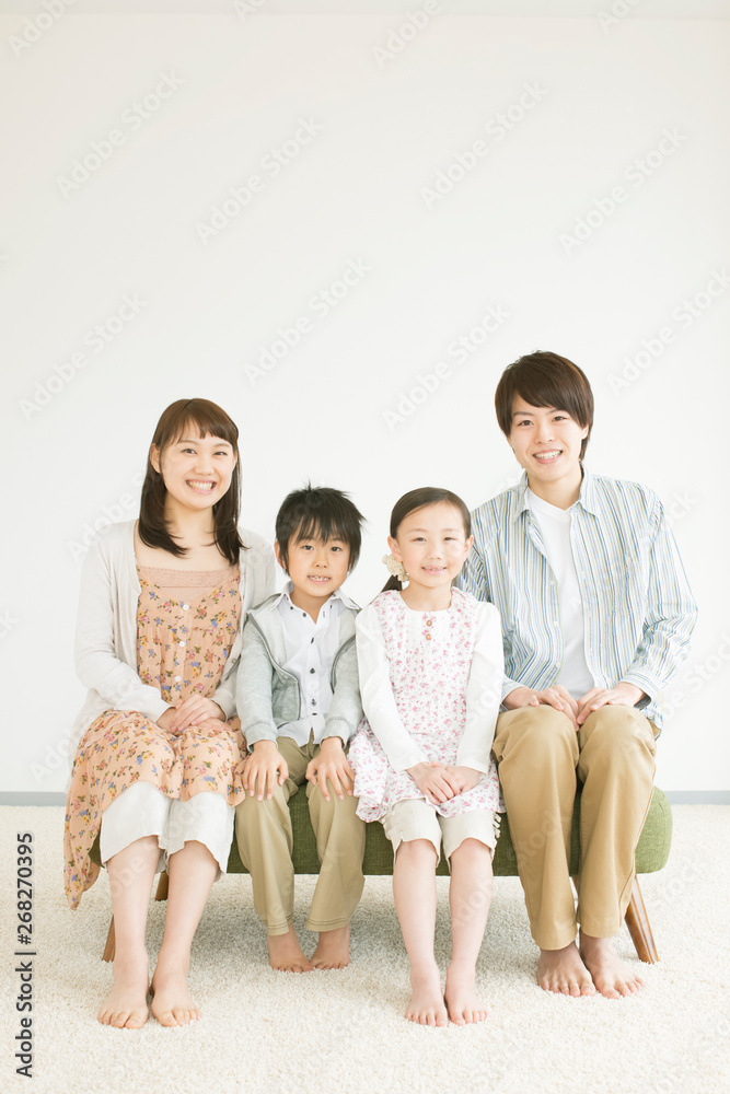 ソファーに座り微笑む家族